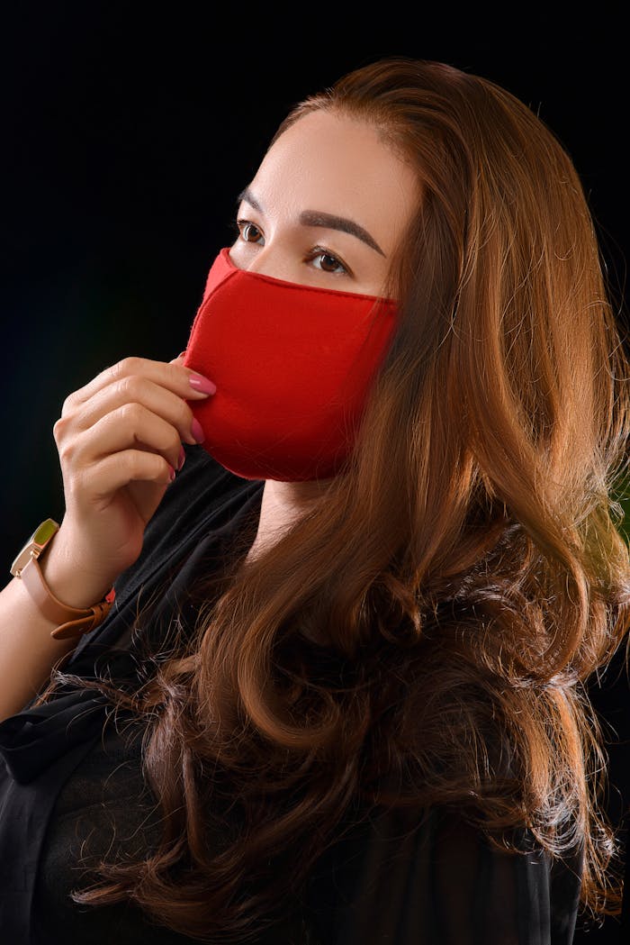 Portrait of a woman wearing a red face mask for health protection and safety.